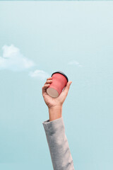 Businessman's hand holding coffee cup garbage waste for recycling on blue sky background....