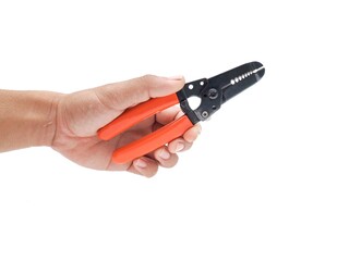 Male hand holding wire stripping pliers with orange handles isolated on white background.