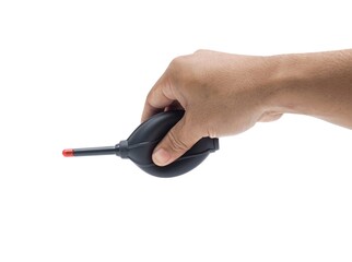 Male hands holding cleaning equipment for camera and computer lens.  Black blower with red tip for blowing dust.  Set isolated on white background.