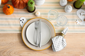 Festive table setting with clean plates, cutlery and ghost for Halloween party