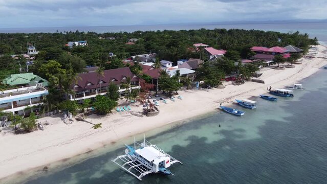 Outrigger diving boat moored at beachfront dive resorts on Malapascua Island ( Logon ), Philippines. Aerial