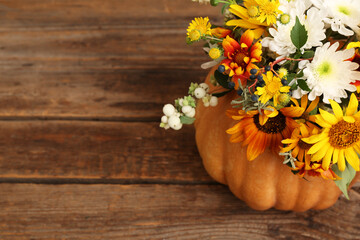 Beautiful autumn bouquet in pumpkin on wooden background