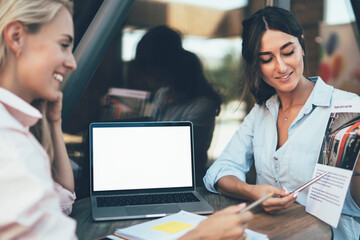 Woman sharing project details with female coworker