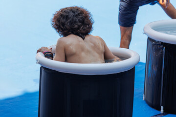 People immersing Themselves in Circular Pools Filled with Water and Ice: Ice Baths