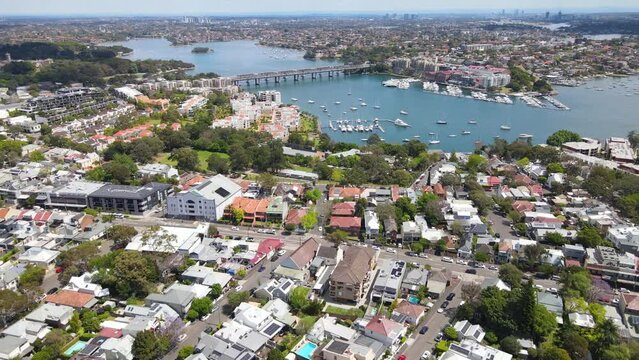 Aerial drone pullback reverse view over Balmain in Sydney, New South Wales, Australia looking toward Sommerville Point and Birkenhead Point on a sunny day    