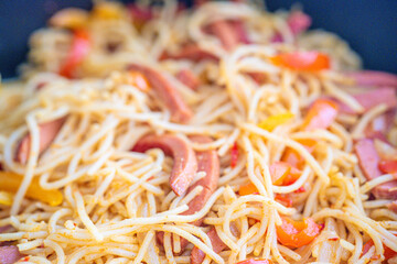 Closeup bowl of spicy spaghetti with sausages