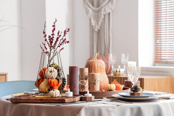 Beautiful table setting with pumpkins and candles for Thanksgiving dinner