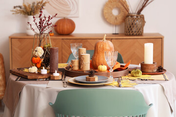Beautiful table setting with pumpkins and candles for Thanksgiving dinner