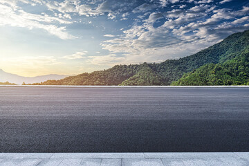 Asphalt road and mountains background at sunset