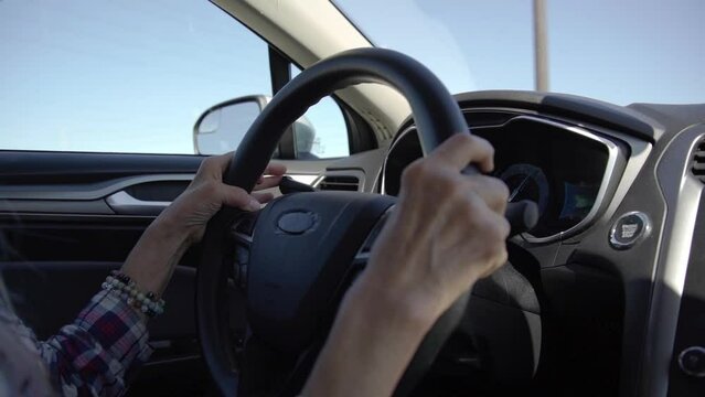 A woman with glasses is driving a car at deserts area during sunshine. Uber driver driving in beautiful place