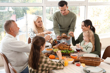 Fototapeta na wymiar Happy family having dinner at festive table on Thanksgiving Day