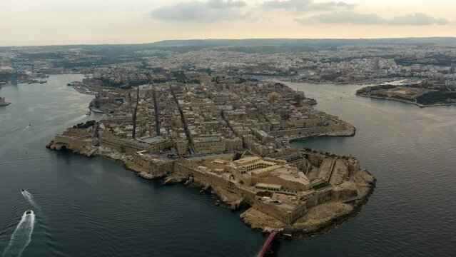 Aerial tilt shot in front of the Fort Saint Elmo and the Valletta cityscape, sunset in Malta