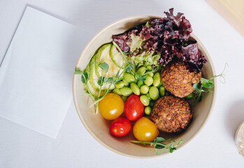 bowl in Chinese style.meatballs with beans, herbs, cherry tomatoes and sauce in a bowl
