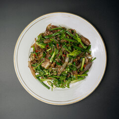 fried pork with herbs and vegetables on a white plate