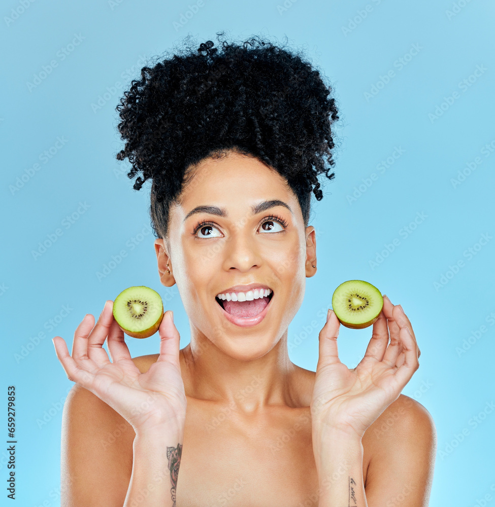 Canvas Prints Kiwi, skincare and excited woman in studio for cosmetic wellness or results on blue background. Happy, face and female with fruit for beauty, pamper or glowing skin routine with detox, shine or glow