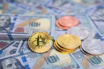 Verities of symbolic coin Bitcoin on mock up one hundred dollars banknotes. Exchange bitcoin cash for a dollars. Cryptocurrency on US dollar bills. Digital modern method of payment.