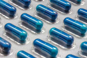Blue medicine tablet in blister pack, close up.