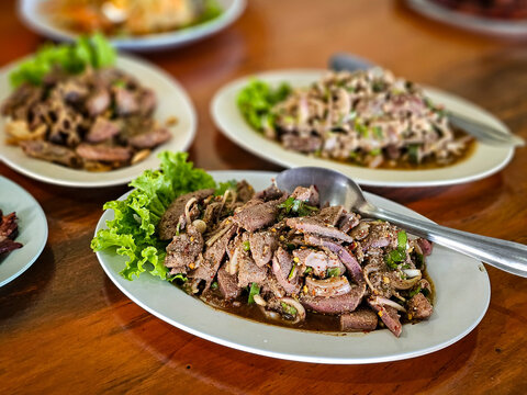 Thai local street food by home cooking chef, Isaan Food, Thai Food Dishes Larb. Pork liver larb thai local Northeast food eating with sticky rice and fresh vegetable