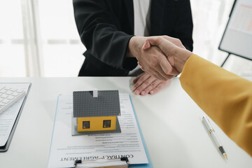 Sales staff discuss home details with customers before agreeing to sign a sales contract, buying...