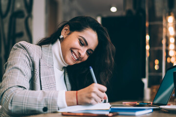 Smiling lady making notes in notepad