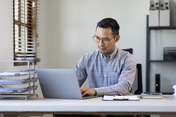 Portrait of Stylish Asian Businessman Works on Laptop, Does Data Analysis and Creative Designer, Looks at Camera and Smiles. Digital Entrepreneur Works on e-Commerce Startup Project
