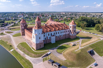 aerial view on overlooking restoration of the historic castle or palace in forest near lake or river