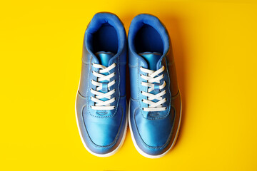 Blue new sneakers on yellow studio background