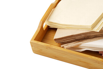 Heap of paper napkins on wooden tray on white background
