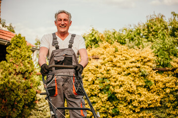 Elderly gentleman meticulously trims his backyard garden in a dapper work suit, showcasing his...