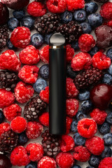 Electronic cigarette on frozen berries top view