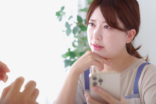 男性のスマホを見て複雑な表情をする女性