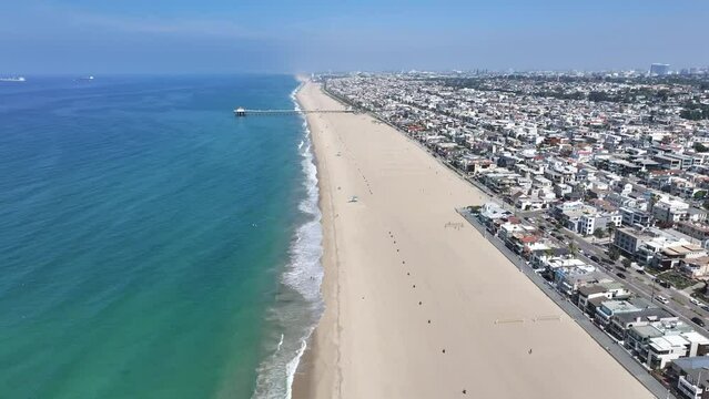 Manhattan Beach, Los Angeles, California, USA - flight along Manhattan Beach with Manhattan Beach Pier which protrudes into the water of Pacific Ocean - aerial video footage
