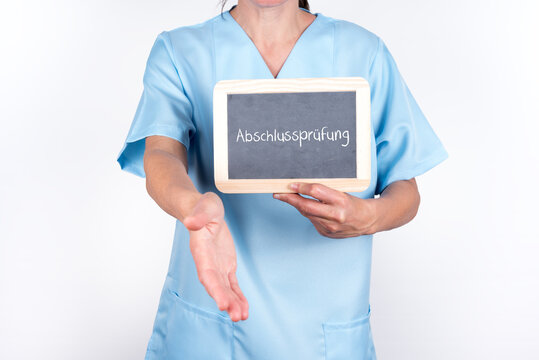 Pflegekraft oder Krankenschwester mit einer Tafel auf der Abschlusspr&uuml;fung steht