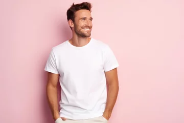 Photo sur Plexiglas Vielles portes Portrait of a happy 30 - year - old man wearing a white t shirts with hands in pocket next to a light pink pastel background. Mock up t shirt concept.
