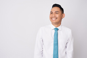 Portrait of a smiling happy young Asian man in formal wear standing confident while looking at empty space isolated on white background