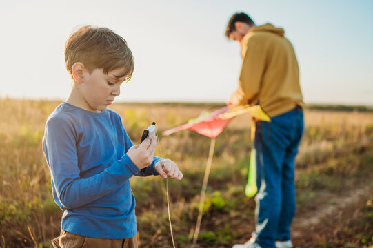 Father and son with kite in field