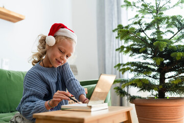 Smiling girl checking list and sitting on sofa at home