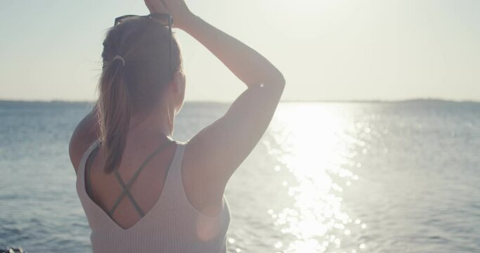 Woman yoga meditates vacation travel enjoys seaside beach sun flares