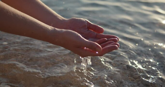 Woman female hands scoop crystal clear clean sea water beach close up