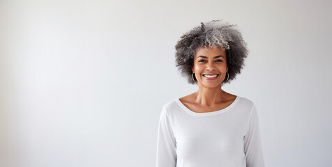 Portrait of smiling proud handsome african american senior woman standing against isolated white background. Wearing a white t-shirt copy space for advertisement or logo - obrazy, fototapety, plakaty