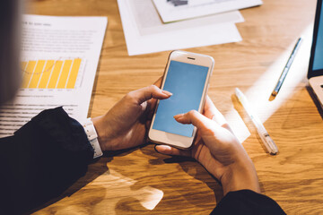 Business lady browsing smartphone in workplace
