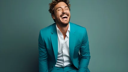 Fotobehang Frisch aussehender Mann in Türkisfarbenem Anzug lacht herzlich vor der Linse © Max