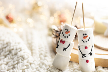 Christmas background with marshmallow snowmen close-up.