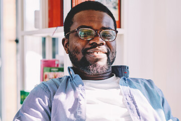 Adult ethnic man interacting with smartphone in light contemporary office