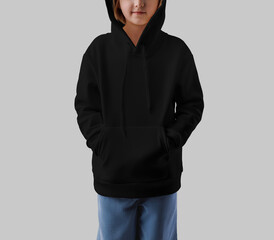Mockup of a black hoodie on a girl in a hood, hands in pockets, isolated on background.
