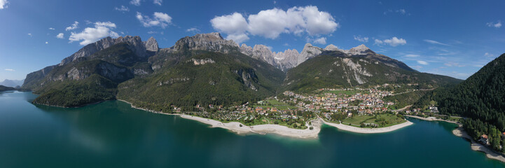Panoramic view of the Alpine Italian town of Molveno on the lake. Aerial view of Lake Molveno, north of Italy in the background the city of Molveno, campanile basso, cima tosa Italian dolomites.