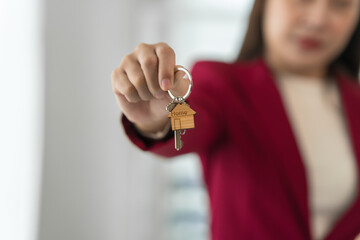 A young Asian real estate agent is reviewing documents and calculating interest rates to inform tenants of monthly installments before entering into contracts to buy or sell real estate.
