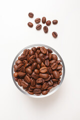 coffee beans in glass bowl on white background shot from above