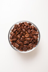 coffee beans in glass bowl on white background shot from above