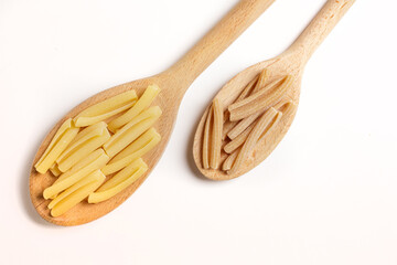 Macaroni durum wheat and wholemeal pasta on a wooden spoon on a white background taken from above